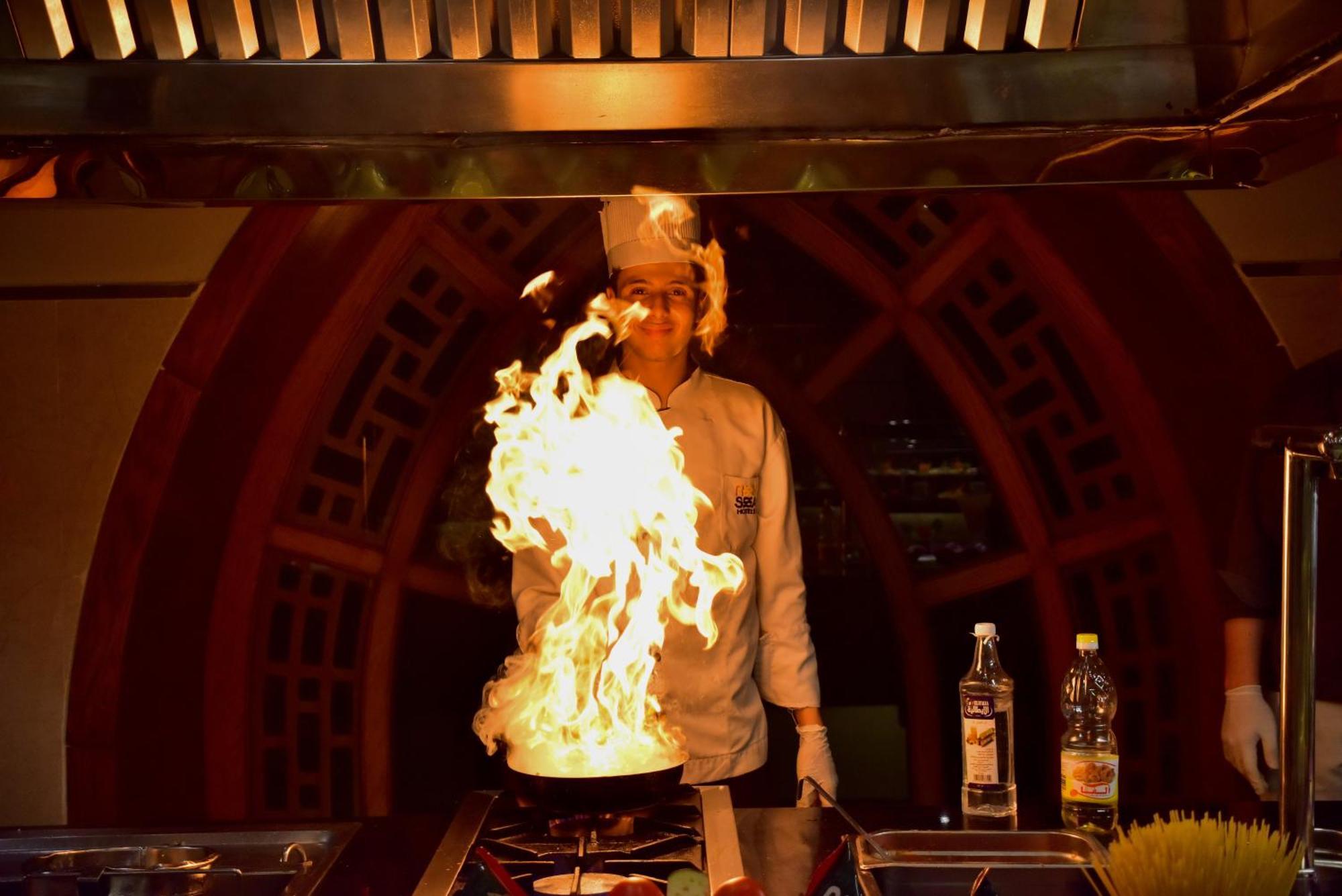 The Grand Hotel Sharm El Sheikh ภายนอก รูปภาพ A chef cooking with a flaming wok
